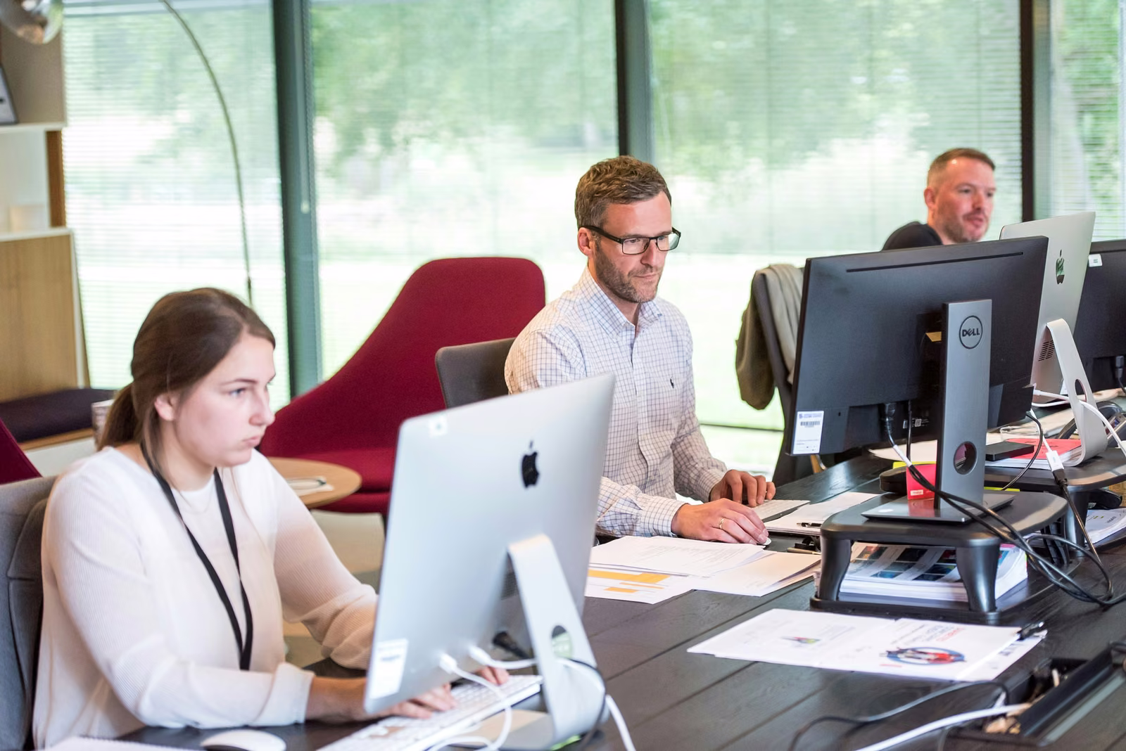 IT support staff working at computer workstations in a bright, modern office